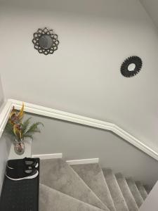 a staircase with two mirrors on the wall and a plant at Modern Basement Suite with Comforts in Winnipeg