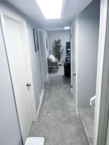 a hallway with a hallway leading to a room at Modern Basement Suite with Comforts in Winnipeg