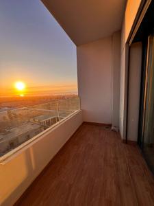 a room with a balcony with a view of the sunset at Appartement Vue Mer & Coucher de Soleil in Aïn Harrouda