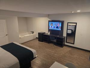 a hotel room with a bed and a flat screen tv at Motel 6 Los Angeles, CA - Downtown in Los Angeles
