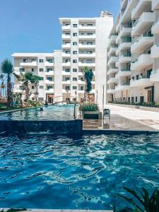 a swimming pool in front of a large building at Appartement Vue Mer & Coucher de Soleil in Aïn Harrouda