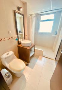 a bathroom with a white toilet and a sink at Depa con alberca a 2 minutos Playa Vicente Fox 1 in Boca del Río