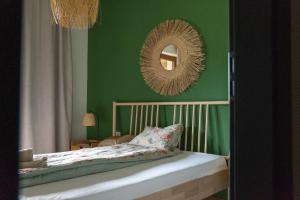 a bedroom with green walls and a bed with a mirror at Leśny Zakątek in Okoniny Nadjezierne