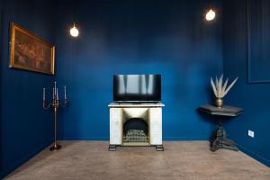 a blue room with a tv on top of a fireplace at Apartment Birmingham in Celle