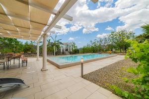 an outdoor patio with a swimming pool and an umbrella at Sicily Stone Cottage with swimming pool in Graniti
