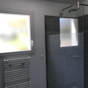 a bathroom with a glass shower with a window at Plain pied idéalement situé in Sainte-Lucie de Porto-Vecchio