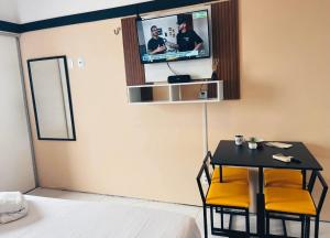 a bedroom with a table and a tv on the wall at Vista Maravilhosa 706 in Fortaleza