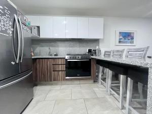 eine Küche mit weißen Schränken und einem schwarzen Kühlschrank in der Unterkunft ML002 - 2BR - 2BTh in Mexiko-Stadt + 4 Fotos