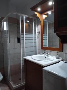 a bathroom with a sink and a shower with a mirror at Secret Garden in Diakopto +14 photos