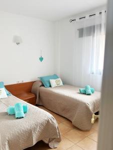 two beds in a room with blue towels on them at Can Blau Formentera Apartamento in Es Pujols +9 photos