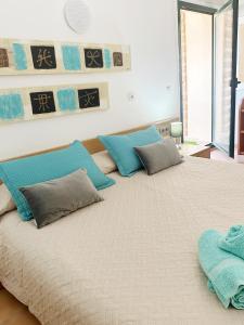 a large bed with blue pillows on top of it at Can Blau Formentera Apartamento in Es Pujols