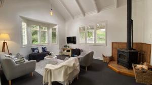 a living room with a couch and a stove at Picture Perfect in the heart of the Village in Greytown