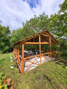 a wooden pavilion in a field with trees at La Ursan in Feteşti