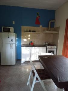 Una cocina con un refrigerador y una mesa dentro. en Puerto Principe, en Pinamar