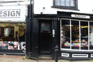 a store with a black door in a street at City heights Central location in Canterbury