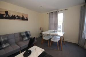 a living room with a couch and a table at City heights Central location in Canterbury