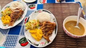 a table with two plates of food and a bowl of soup at La Bamba in Termales - agua caliente - nuqui