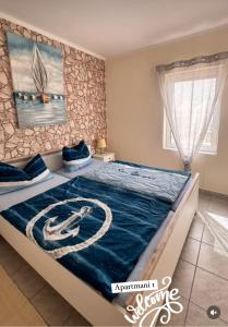 a bedroom with a large bed with a blue comforter at Ferienhaus in Kroatien in Maslenica