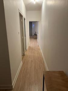 an empty hallway of a apartment with white walls and wood floors at Appartement de 60 m2 au centre ville de morez in Morez