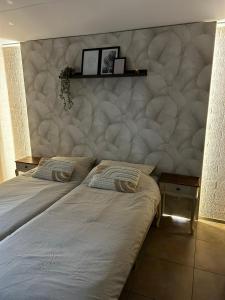 2 camas en un dormitorio con una gran pared acolchada en Vakantiehuisje Heuvelland, en Simpelveld