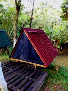 a tent with a red roof sitting on a bench at Eco Cabana 01 in Santo André