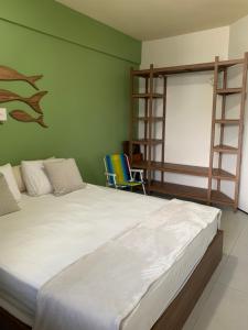 a bedroom with a large white bed and a green wall at Flat São Luís Litorânea in São Luís