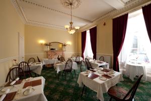 a dining room with white tables and chairs at The Ben Doran Guest House in Edinburgh