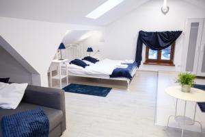 a living room with two beds and a couch at Apartamenty Stacja Kasina in Kasina Wielka