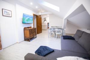 a living room with a couch and a dining room at Apartamenty Stacja Kasina in Kasina Wielka