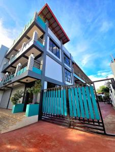 a house with a blue fence in front of it at NOBER Apartments in Puerto Princesa City