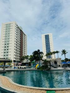 a large swimming pool with two tall buildings at Apto Premium Resort in Salinópolis