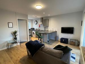 Una sala de estar con un sofá y una cocina. en Parkside Apartments Boston, en Boston