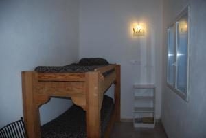 a small bed in a room with a light on the wall at Residence Ribellinu in Pianottoli-Caldarello