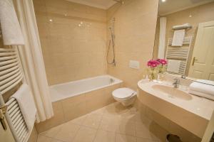 a bathroom with a sink and a toilet and a bath tub at Angelis in Prague