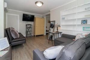 un soggiorno con un divano e una TV di The Inn At Ocean Grove a Ocean Grove