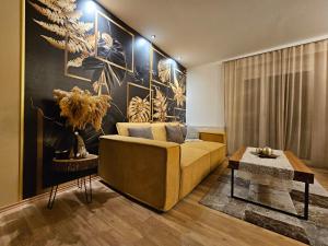 een woonkamer met een gele bank en een muur bij Ferienwohnung Blick ins Grüne in Rossleithen