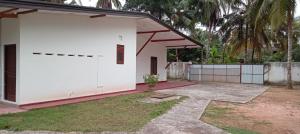 a small white house with a garage at Villa Paradiso in Wadduwa