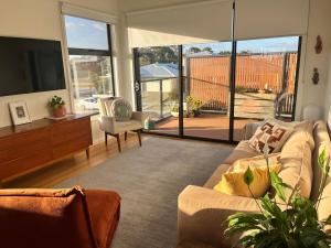 a living room with a couch and a flat screen tv at Bright, spacious apartment in Torquay in Torquay