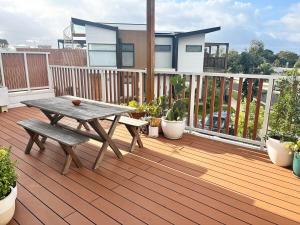 a wooden deck with a picnic table and bench at Bright, spacious apartment in Torquay in Torquay