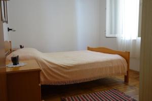 une chambre avec un lit, une table et une fenêtre dans l'établissement Apartments Nev, à Blato