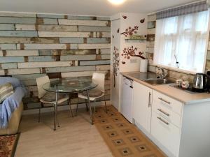 a kitchen with a glass table and a kitchen with a brick wall at Lark Rise B&B in Wangford