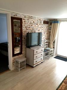 a living room with a television on a dresser at Lark Rise B&B in Wangford