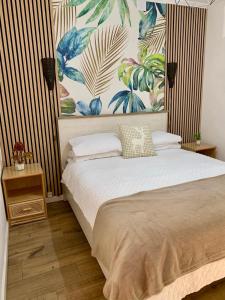 a bedroom with a bed with a large painting on the wall at Casa Sol e Mar in Carvoeiro