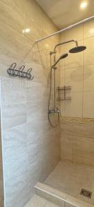a shower with a glass door in a bathroom at Park Hostel in Šiauliai