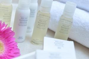 a group of four bottles of facial treatmentene next to a flower at Angelis in Prague