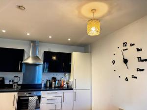 a kitchen with a clock on the wall at Cozy Private Room with Free Wi-Fi in Colchester
