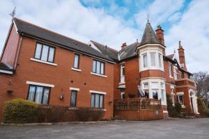 a large red brick house with a turret at Trivelles Park Hotel in Preston