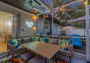 a patio with a wooden table and chairs at 3BR Sunshine Retreat with Heated Pool, Cold Plunge and Games in Bradenton