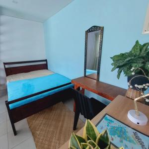 a bedroom with a bed and a desk with a mirror at Bodhi Yoga House w Free Yoga in General Luna