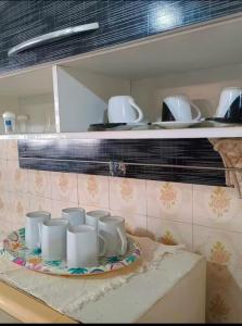 Casa entera en el Centro de Búzios - Paralela a la Rua das Pedras, zona premium y sin tránsito في بوزيوس: مجموعة من الكؤوس البيضاء على طبق في المطبخ